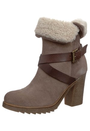 Hnědá semišová kotníková bota s masivním podpatkem, lemovaná beránkem, s dekorativním tmavě hnědým koženým páskem se mosaznou přezkou.