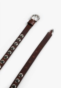 Cinturón de cuero marrón con hebilla de metal plateado, remaches decorativos de metal a lo largo de un lado y diseño de punta.