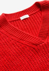 Maglione rosso a maglia con scollo a V, caratterizzato da una trama a coste e da un'etichetta di marca sul collo. Realizzato in tessuto morbido e resistente.