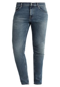 Slim-fit jeans i denim i mellanblå nyans med lätt blekning, femficksdesign och knappstängning i metall. Material i bomull med mjuk textur.