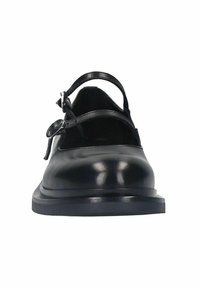 Chaussures en cuir noir avec un bout rond, présentant deux fines lanières sur le coup de pied et une semelle plate et basse. Texture lisse et design minimal.
