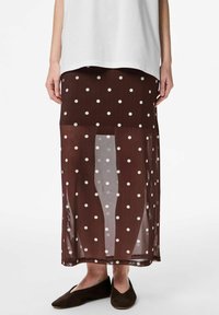Gonna midi marrone a pois in tessuto trasparente, con pois bianchi, taglio dritto e orlo che termina sotto il polpaccio.