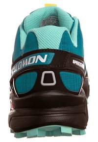 Salomon Speedcross löparsko har en övre del i svart och teal, texturerat mesh-tyg, förstärkt h�äl och en greppvänlig gummisula.