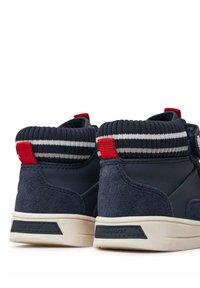 Sneakers alte di colore blu navy in suede e materiale sintetico, con un colletto rigato con strisce rosse e bianche e un accento rosso sul tallone.