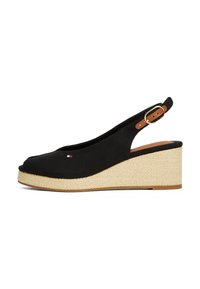 Black canvas wedge sandals with a peep toe, featuring a woven jute sole and a brown leather ankle strap with a gold buckle.