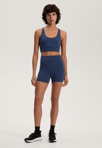 Navy blue urheilu cropped-top ja korkeavyötäröiset shortsit joustavasta materiaalista, joissa on sileä pinta ilman näkyviä kuvioita tai lisäosia.