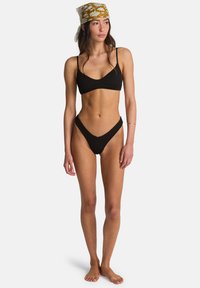 Set bikini nero con motivo a costine strutturato. Il top presenta spalline sottili e scollo a U, mentre il fondo ha un design a taglio alto.