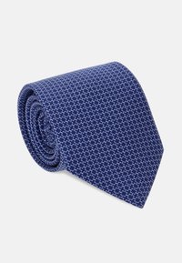 Tummansininen solmio, jossa on geometrinen kuvio pienistä valkoisista muodoista, neatly rullattu, valmistettu sileästä kankaasta, jossa on pehmeä rakenne.