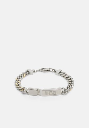 Pulsera de metal plateado con una combinación de eslabones lisos y texturizados. Presenta un cierre grabado reconocible. Incluye acentos dorados.