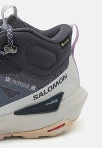 Salomon tursko til fotturer med grå tekstil overdel, GORE-TEX-merke, gummisåle og aktiv chassis for stabilitet. Snøring.