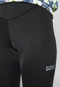 Czarne spodenki rowerowe wykonane z elastycznego materiału z wkładką wyściełającą. Posiadają logo po boku oraz gładką teksturę.