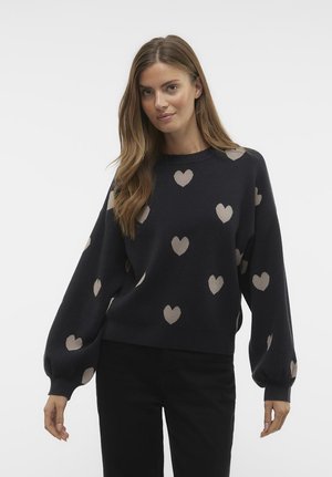 Sweater in dark navy with beige heart patterns. Features a rounded neckline, long balloon sleeves, and a relaxed fit. Soft knit texture.