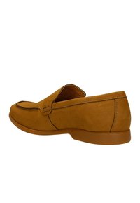 Scarpa slip-on in suede marrone con punta arrotondata, cuciture decorative e suola in gomma bassa e flessibile. Presenta una texture esterna liscia.