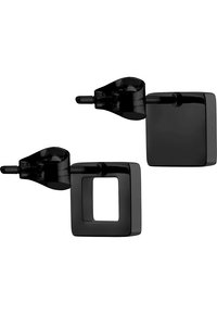 Zwarte vierkante studs met een glanzende afwerking, waarbij één een holle kern heeft, met een modern geometrisch ontwerp.