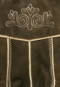 Braunes Wildleder mit weißem besticktem Blumenmuster am oberen Rand. Verfügt über kontrastierende Nähte entlang der Nähte und Kanten. Strukturierten Oberfläche.