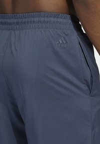 Marinfärgade sportshorts i lättviktsmaterial, med elastisk midja, sidofickor och en diskret Adidas-logotyp.