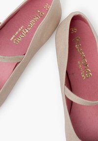 Ballettschuhe aus beigem Stoff mit pinken Innensohlen. Merkmale einen Riemen über dem Fuß und goldene Beschriftung auf der Innensohle. Größe 35.