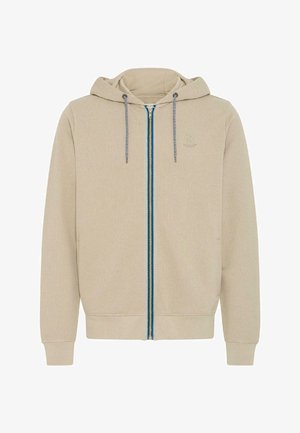 Bézs színű cipzáros kapucnis pulóver texturált felülettel, kék és szürke cipzár részletekkel, valamint egy kis logóval a bal mellrészen. Húzózsinóros kapucnival rendelkezik.