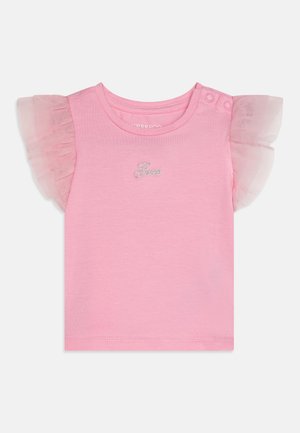 T-shirt rosa de manga curta feita de algodão macio. Apresenta mangas em tule transparente com babados e um logo prateado "Guess" na parte da frente.
