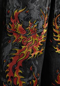 Roter und gelber Flammendrache auf schwarzem Denimstoff gestickt mit sichtbaren Nähten und Struktur.