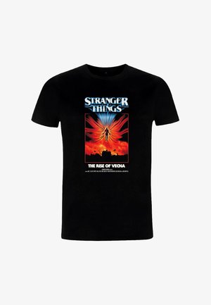 Sort bomulds-T-shirt med "Stranger Things"-grafik. Designet indeholder levende farver med en silhuet mod en flammende baggrund.