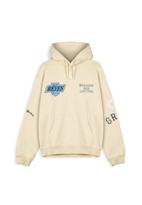 Sudadera color crema con un bolsillo frontal, un gran logo azul de "Reyes" y el texto "Burning and Looting" en la parte delantera y en la manga izquierda.