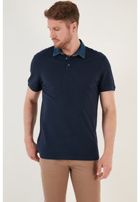 Námořnická polo košile vyrobená z bavlny, s límcem připomínajícím denim, krátkými rukávy, zapínáním na tři knoflíky a přiléhavým střihem.