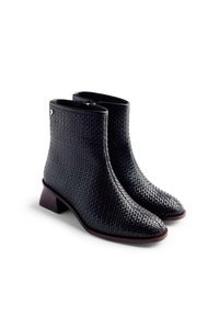 Botas de tobillo de tejido negro con punta cuadrada y tacón bajo. Con cierre de cremallera y material sintético texturizado.