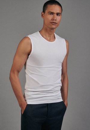 Witte mouwloze tanktop van zachte stof, met een ronde hals en een getailleerd ontwerp. Gekocht met donkere broek, minimalistische stijl.