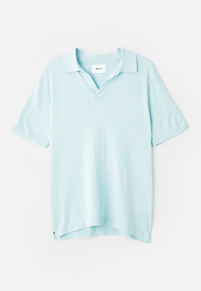 Polo shirt à manches courtes de couleur bleu clair, avec un col en V, coupe décontractée, texture douce et fentes latérales pour faciliter les mouvements.