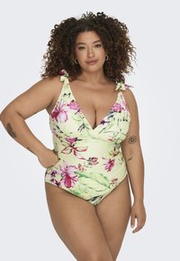 Heled lillatäheline ujumiskleit heledas kollases, millel on V-kujuline kaelus, volangidega õlapaelad ja kogutud talje detailid.