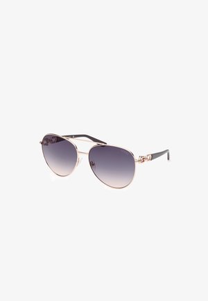 Ochelari de soare aviator din metal cu lentile gradient, accente aurii pe ramă și brațe negre care prezintă elemente decorative.