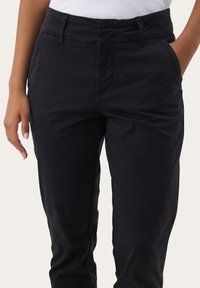 Pantaloni in cotone blu scuro con taglio dritto, tasche laterali e una texture liscia. La vita presenta passanti per cintura per una vestibilità regolabile.