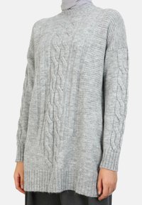 Lette grå kabelstrik sweater med ribbede manchetter og søm, blød tekstur, afslappet pasform og lodret ribbning med en sideindsnit.