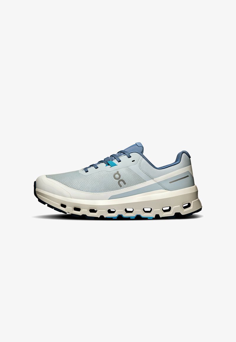 Baskets de course bleu clair avec un supérieur en maille respirante, semelle rembourrée et motif découpé notable le long de la semelle intermédiaire. Accents et lacets gris.
