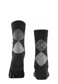 Calcetines negros con un patrón de argyle de diamantes en tonos gris claro y gris oscuro. Hechos de un material texturizado, con un puño acanalado en la parte superior.