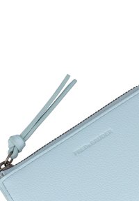 Portafoglio in pelle azzurro chiaro con una finitura testurizzata, dotato di chiusura a zip e un cordino in pelle annodato. Accentuato da delicata scritta del marchio.