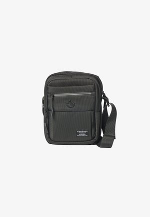 Bolso compacto negro de hombro con bolsillo frontal con cremallera, correa ajustable, logo de hoja en relieve y etiqueta Koroshi Premium en el panel frontal inferior.