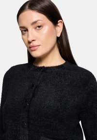 Czarny puszysty kardigan z okrągłym dekoltem, ozdobiony pięcioma czarnymi guzikami i miękką teksturą, idealny na codzienne wyjścia.