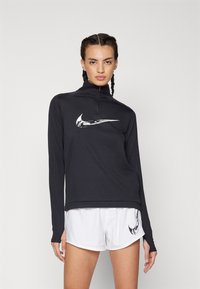 Black long-sleeve athletic shirt with a quarter zip and white Nike swoosh logo, paired with white athletic shorts featuring a small logo.