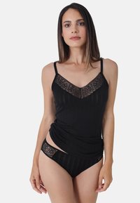 Black camisole with lace accents, featuring thin straps and a ribbed texture. Paired with black lace-trimmed panties.