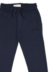 Pantaloni della tuta blu navy in misto cotone, con vita elastica e cordoncino, e un discreto logo ricamato sulla coscia.