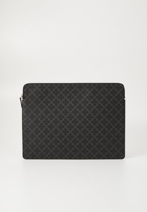 Must musta kate, millel on tekstuuriga muster, mis sisaldab nelinurkset võrgu kujundust. Lõpetatud kuldse tõmbluku ja minimalistlike servadega.