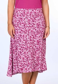 Blumiger Midirock mit einem lebhaften pinken Hintergrund und weißen Blumen, aus leichtem Stoff, mit einem ausgestellten Saum und einem elastischen Bund.