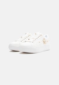 Baskets blanches à surface lisse, ornées de broderies dorées représentant une étoile et une constellation. Bout arrondi, semelle plate et design à lacets.