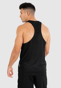 Schwarzes, geripptes Tank-Top mit Racerback-Design, aus einem strukturierten Stoff gefertigt. Hat ein kleines Etikett an der Seite.