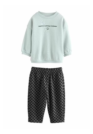 Sudadera de color verde azulado claro con el texto "HAPPY LITTLE HUMAN", combinada con pantalones cortos de estampado a cuadros negro y gris, ambos fabricados en material suave.