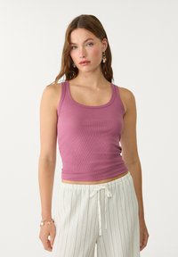 Lila, gerippte Tanktop mit breiten Trägern und rundem Ausschnitt, kombiniert mit leichten, gestreiften, weiten Hosen.