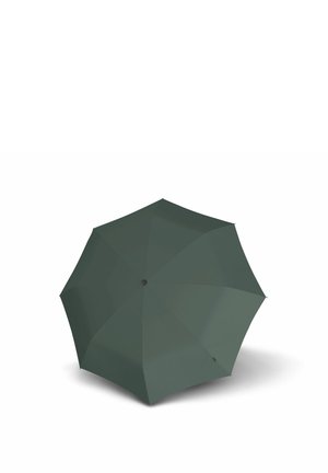 Dark green closed umbrella standing upright on a white surface, shown from above with visible spokes and center button.