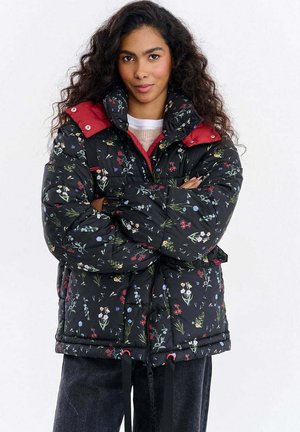 Pikowana kwiecista kurtka w kolorze czarnym z czerwonym kołnierzem, posiadająca sznurek ściągający u dołu, wielokolorowe wzory kwiatowe oraz zamek błyskawiczny.